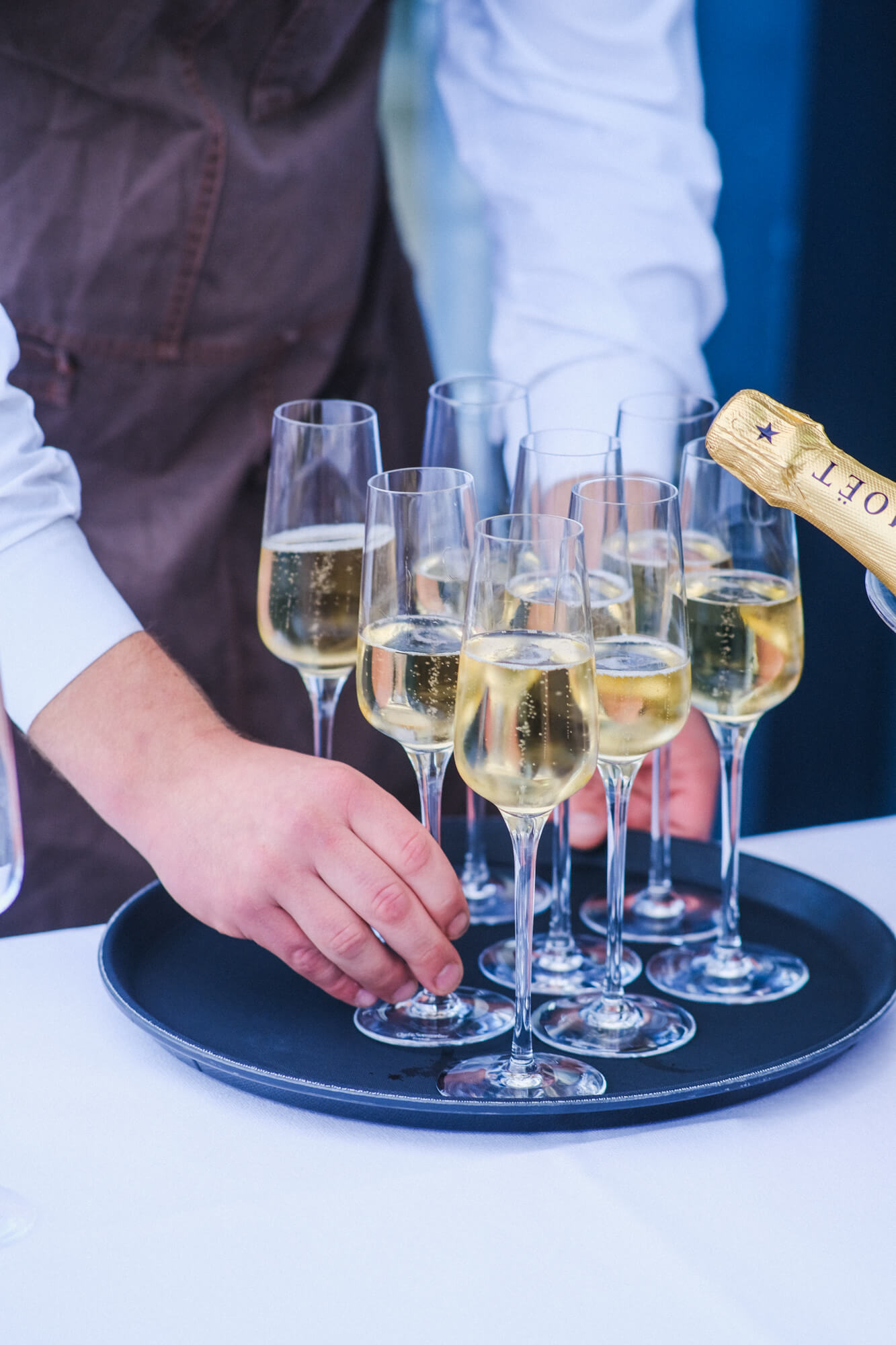 Albertz Catering Hannover - Ein Kellner der ein Tablett mit prickelnden Sektgläsern in der Hand hat, bereit zum stilvollen Servieren